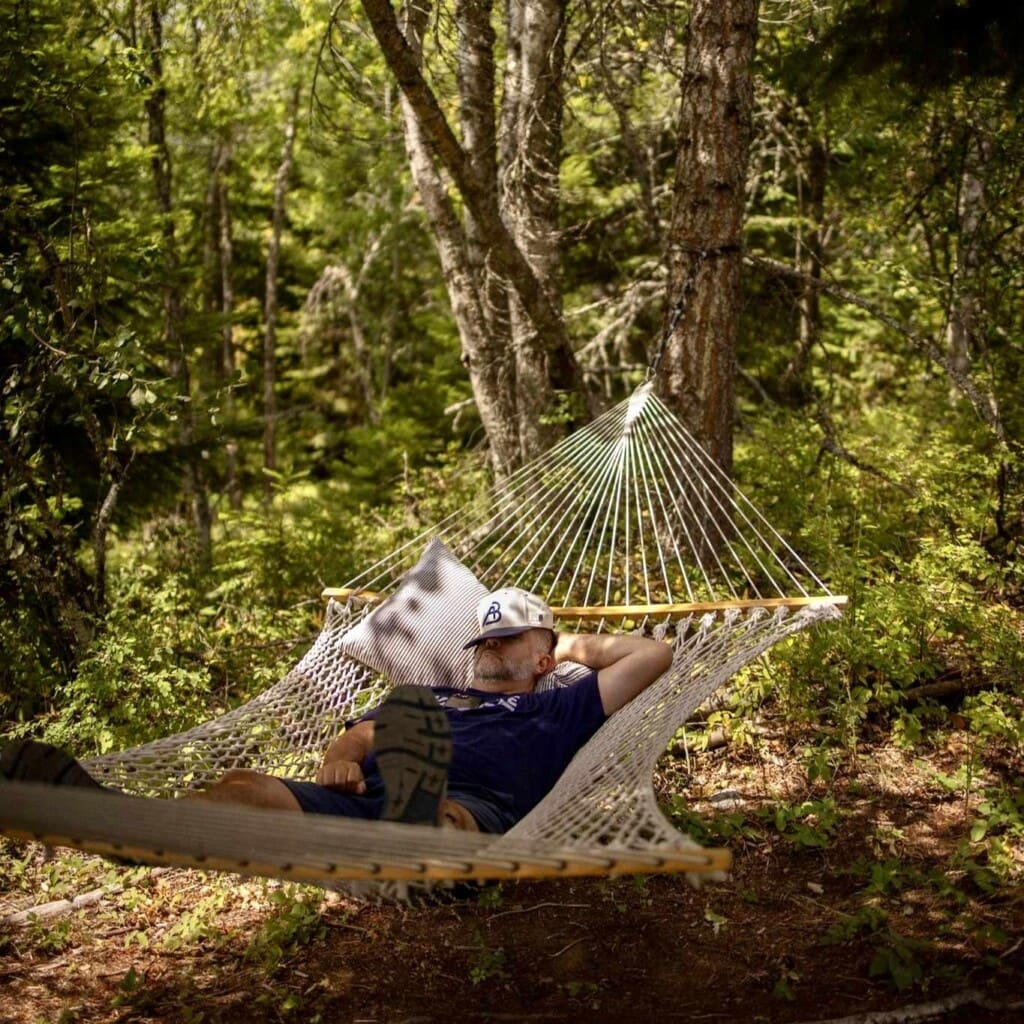 Man napping in a hammock in the woods